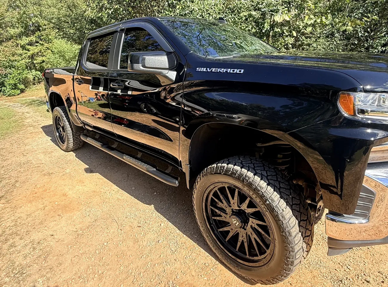 Black Chevrolet Silverado on black wheels with a high-gloss finish